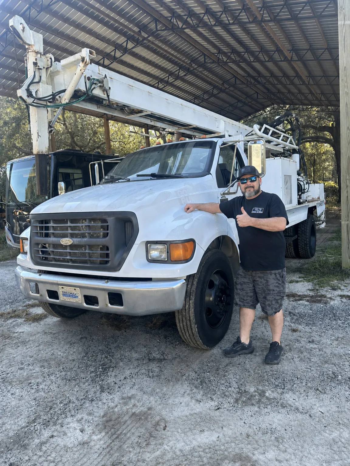 AL’s team member beside a white drill rig truck